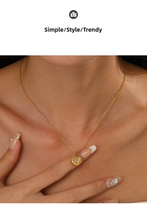 Close-up of 14K gold-plated heart necklace with gemstone on a model's neck