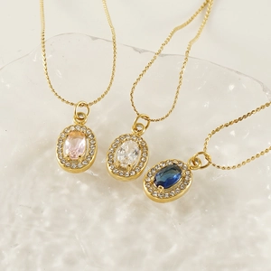 Dettaglio di tre collane placcate in oro 18K con zirconi ovali rosa, bianco e blu