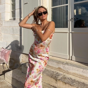 Robe longue satinée ajustée à fleurs avec fines bretelles sous une lumière naturelle