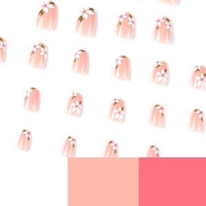 Pink press-on nails set with hand-painted white flower patterns and green leaf accents