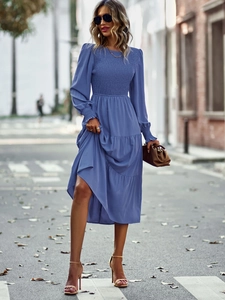 Détails de la robe bleue à manches longues avec buste plissé et ourlet à volants