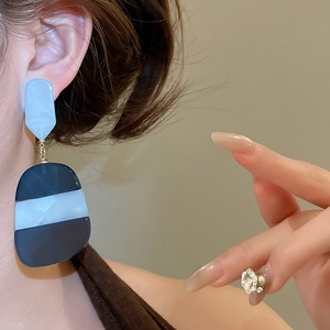 Detail showing acetate oval geometric drop earring with blue and white marble texture