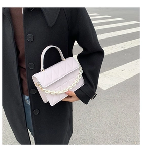 Détails du sac bandoulière rose matelassé avec chaîne acrylique blanche et losanges