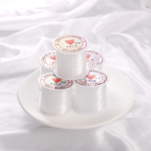 Multiple sizes of transparent elastic crystal beads cord on elegant white silk background