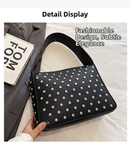 Detail shot of black faux leather shoulder bag featuring dense silver metal rivet accents