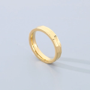 Macro detail of golden faceted hammered texture ring with geometric surface reflections