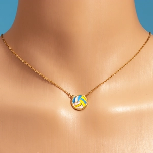 Detailed close-up of a gold-plated volleyball pendant necklace on a neck model