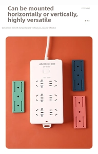 Detail of white 6-outlet power strip with three colored wall mounting brackets