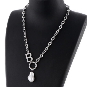 Modern silver B-letter pendant necklace with baroque pearl on a black mannequin display