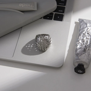 Détail macro d'une bague en acier inoxydable argenté avec texture géométrique sur un PC