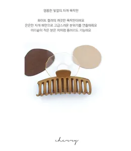 Close-up of a large matte brown hair claw clip on a stylish decorative background