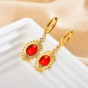 Dettaglio macro di orecchini con rubino placcati oro con design a raggiera ovale e chiusura