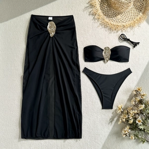 Three-piece black bikini set with gold metal accents and matching sheer mesh skirt