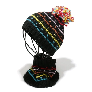 Detail of black knitted hat and scarf set with rainbow stripes and colorful pom-poms