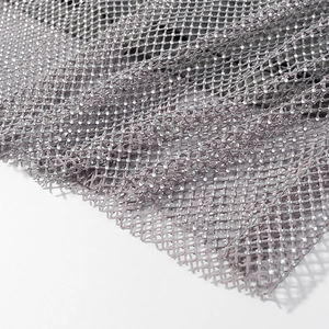 Gros plan de strass étincelants sur tissu mesh gris à texture translucide