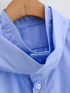 Detail of blue hooded shirt featuring smooth plain fabric and white resin buttons