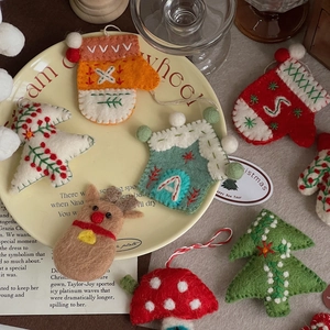 Detail of wool felt Christmas ornaments featuring reindeer, gloves and stars on a plate