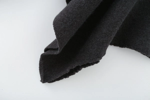 Close-up of dark grey knit fabric texture and high-quality seam detailing of the poncho