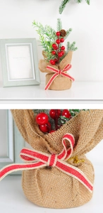 Detailed view of mini Christmas tree with red berries, pine cones and burlap base decor