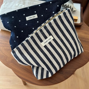 Detailed macro of minimalist denim canvas makeup bags with polka dots and stripes