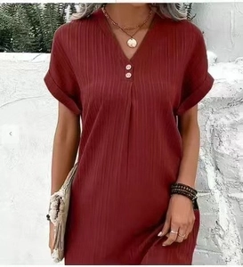 Dettaglio di un abito bordeaux con scollo a V, maglia a coste e bottoni decorativi