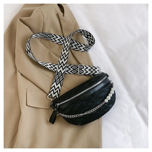 Close-up of black textured chest bag featuring pearl chain and geometric woven strap