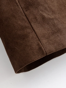 Gros plan détaillé de la texture en daim marron et des coutures sur un blazer olive