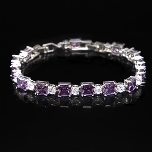 Detail of tennis bracelet with purple square gems and round crystals on black background