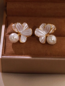 Gros plan de boucles d'oreilles fleurs avec perles blanches dans un écrin en velours