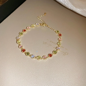 Detailed macro view of gold plated bracelet with colorful circular zircon stones