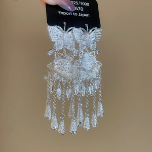 Detailed close-up of 925 sterling silver hollow butterfly floral tassel earrings