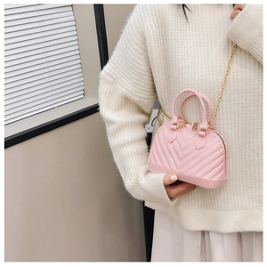 Pink jelly shell bag with V-shaped texture and golden chain strap shown as a crossbody bag