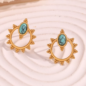 Macro shot of gold floral border with oval turquoise inlay on vintage style earrings