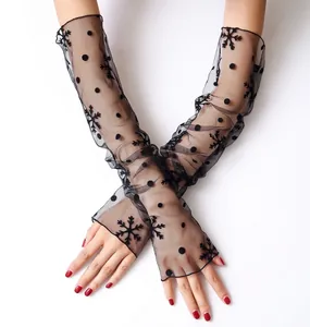 Close-up of long black mesh sleeves featuring delicate polka dots and snowflake flocking patterns