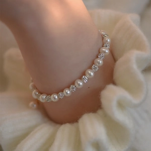 Close-up of 925 silver freshwater pearl bracelet with rhinestone ball charm on wrist