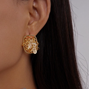 Détail de boucles d'oreilles carrées plaquées or 18 carats avec maille et cristaux