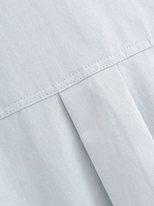 Detailed close-up of light blue twill fabric texture and precision stitching on jacket