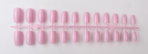 Detail of 24-piece long square pastel pink press-on nails on a plastic sprue connector