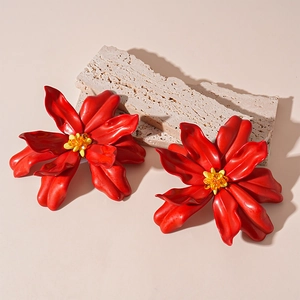 Detailed view of oversized red acrylic flower earrings with yellow beaded stamen center