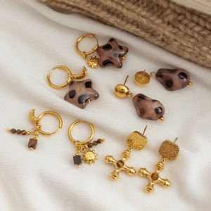 Détails de cinq boucles d'oreilles bohèmes avec motif léopard et breloques dorées
