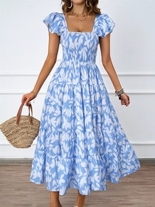 Détail de robe d'été fleurie bleue avec bustier froncé et ourlet à volants étagés