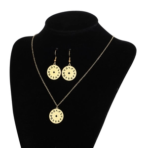 Detailed view of golden zodiac constellation necklace and earrings set on a black bust