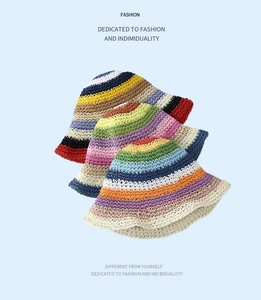 Three colorful handmade crochet straw bucket hats with rainbow stripes on blue background
