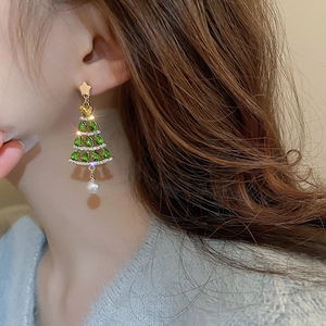 Close-up of a festive Christmas tree earring with green crystals and a pearl drop pendant