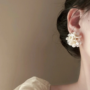 Close-up of elegant floral cluster stud earrings with white pearl-like petals