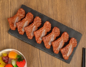 Detailed set of 7 realistic faux roasted meat bone models on a dark slate display tray