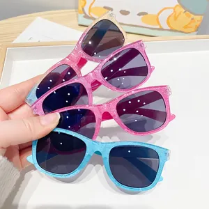 Stack of colorful glitter square sunglasses for kids with vibrant PC frames and dark lenses