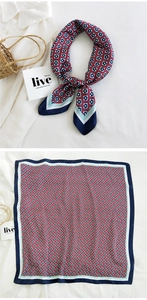 Detailed view of square silk scarf with floral geometric pattern and smooth satin finish