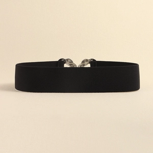 Detail of black elastic waist belt with textured fabric and silver chain metal buckle