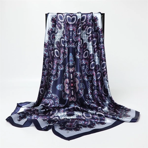 Détail de texture d'un foulard en satin imprimé paisley aux motifs bleus et roses